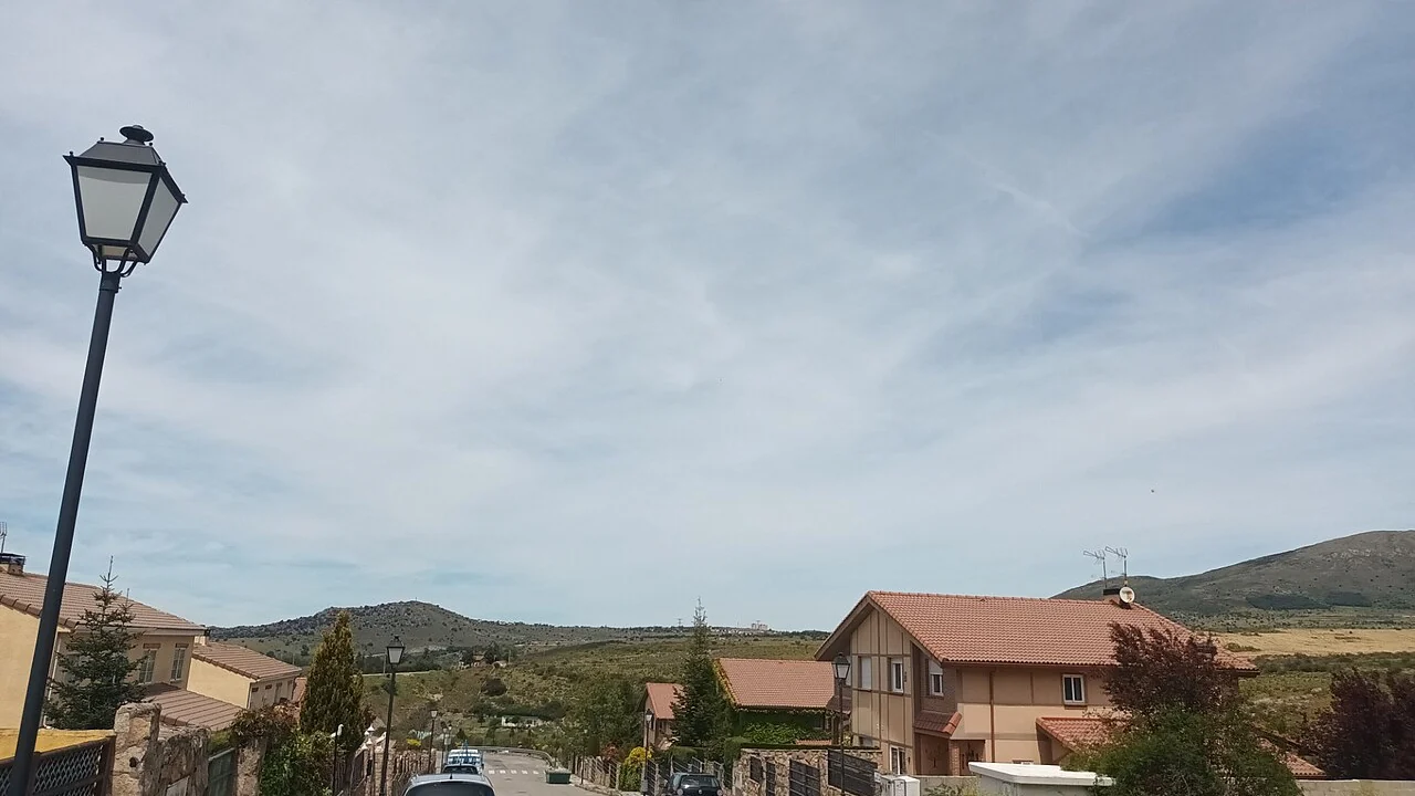 Panoramic view of Los Ángeles de San Rafael in the far distance from La Estación de El Espinar.jpg