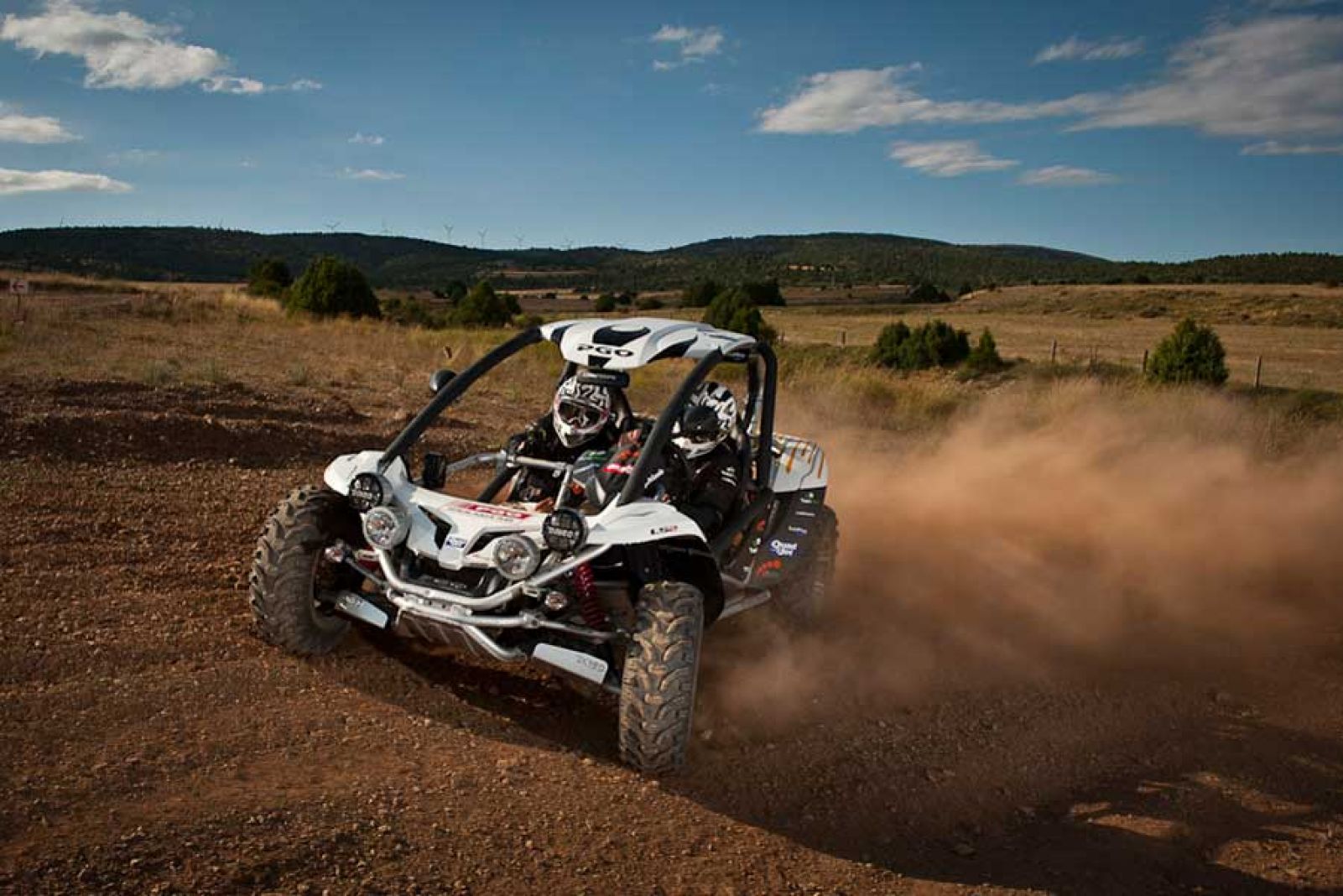 Buggy libre circulando por pista abierta levantando polvo
